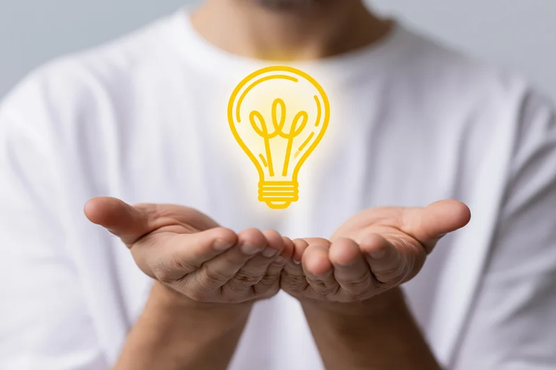 Man holding glowing lightbulb symbol in cupped hands
