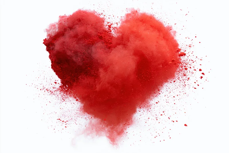 Red powder exploding in heart shape against white background