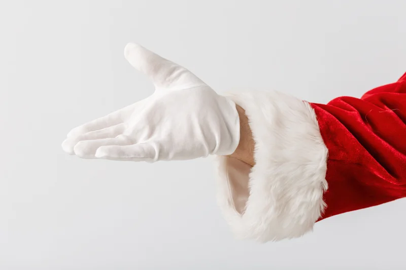 Santa's gloved hand extended palm up against white background