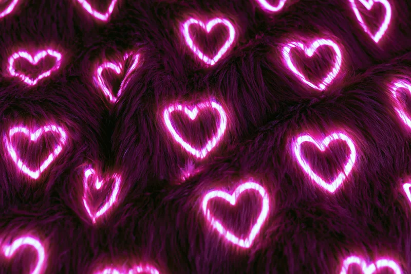 Glowing neon pink heart outlines scattered across a dark furry fabric surface