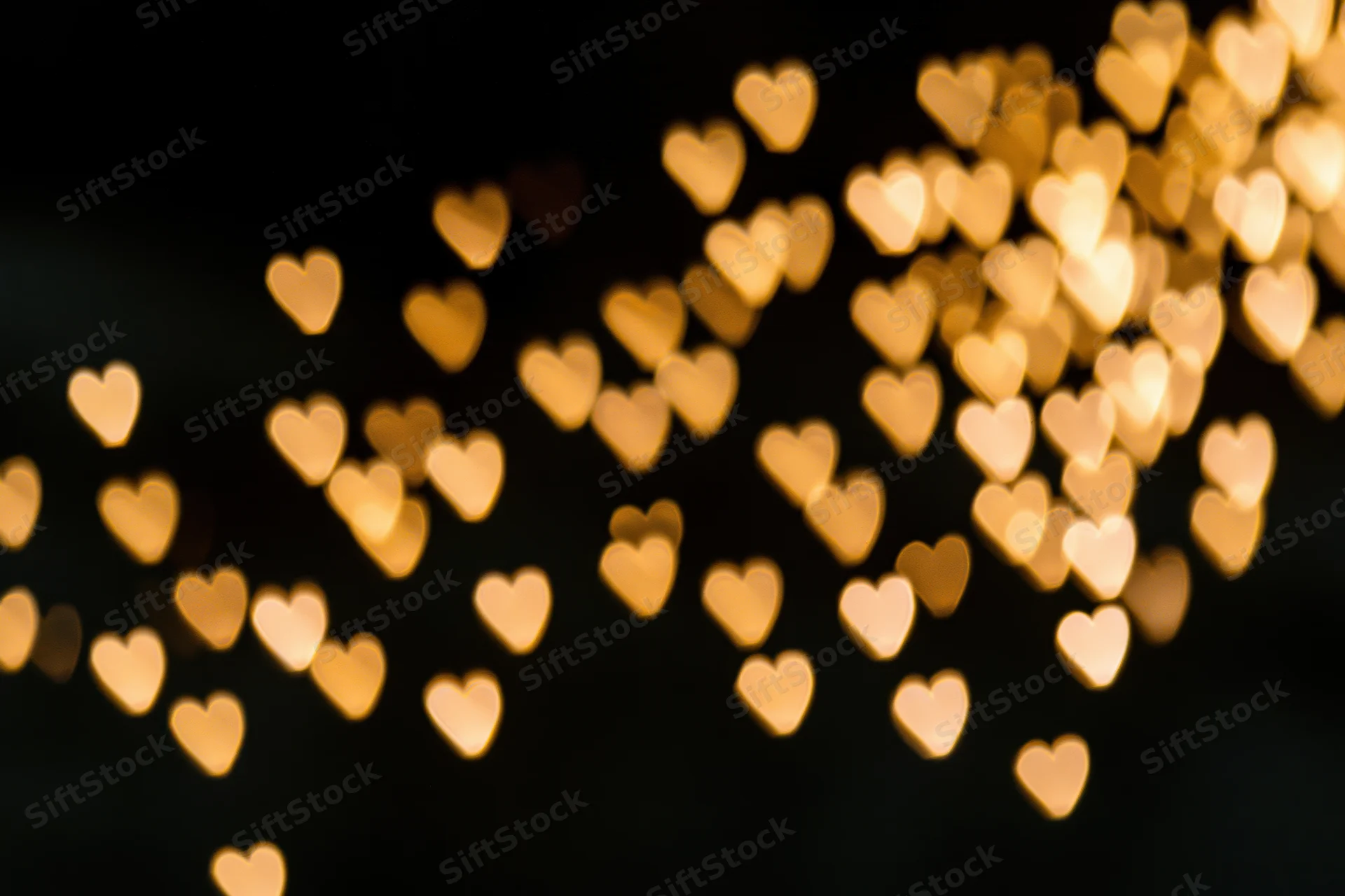 Heart-shaped bokeh lights glowing softly against a dark background