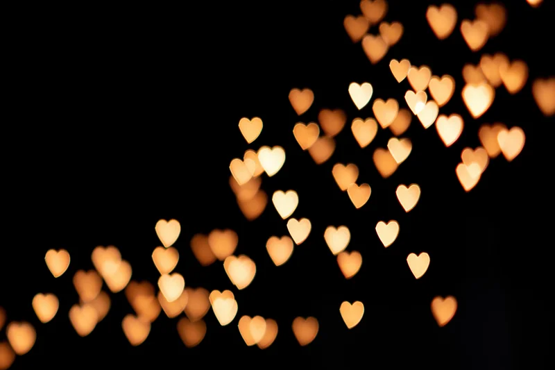 Heart-shaped bokeh lights scattered across a dark background