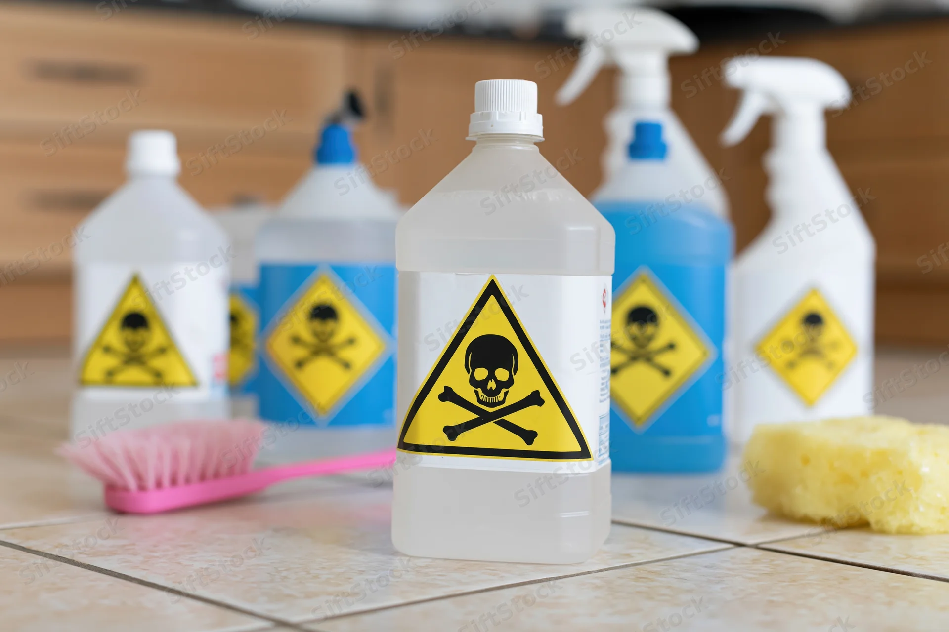 Hazardous cleaning chemicals with skull and crossbones labels on kitchen countertop