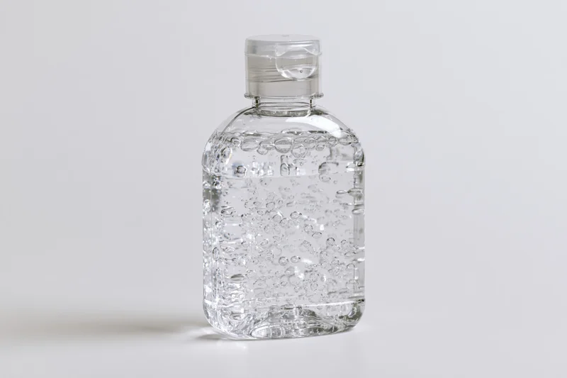 Clear plastic hand sanitizer bottle filled with gel on white surface