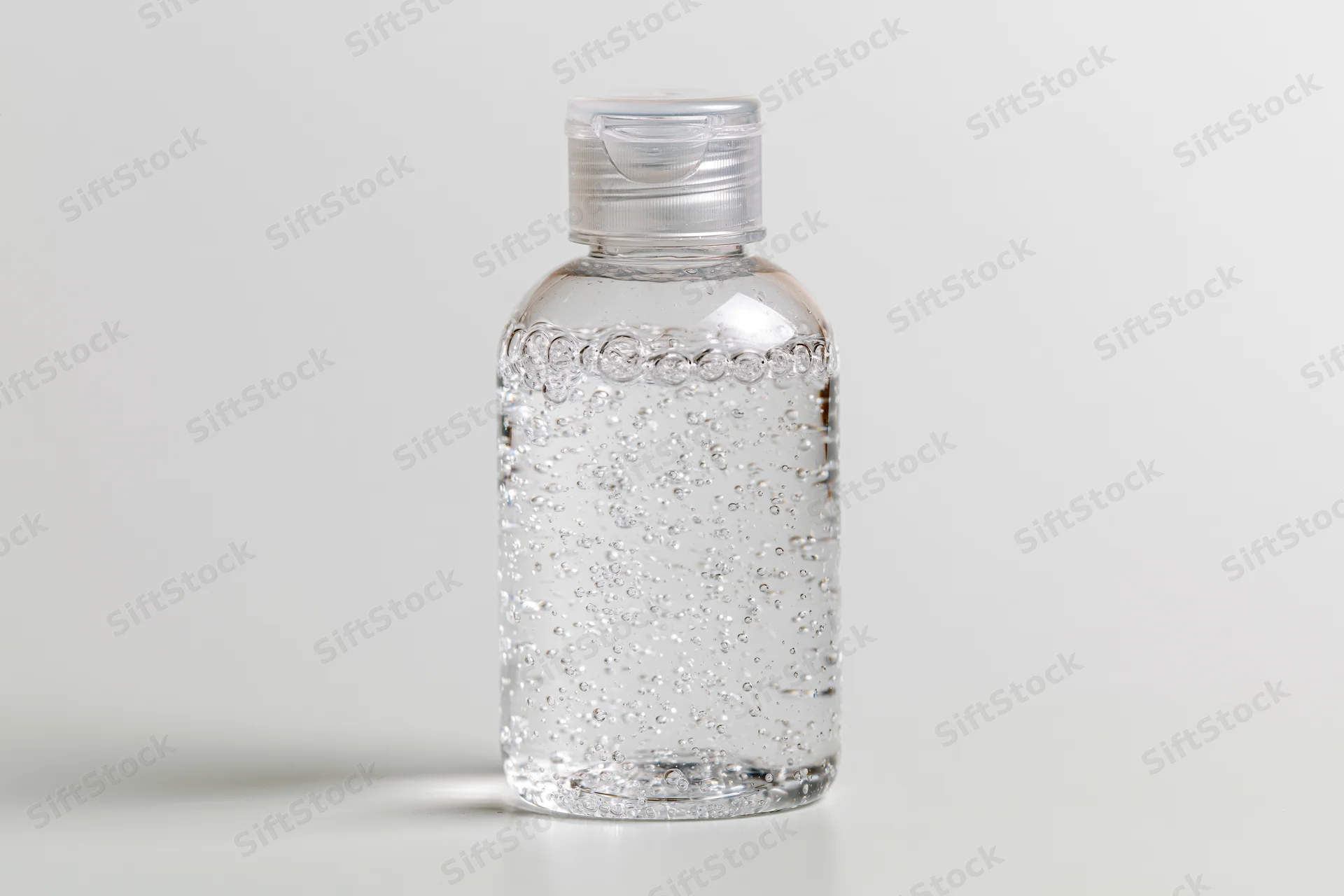 Clear plastic bottle of hand sanitizer gel on white background