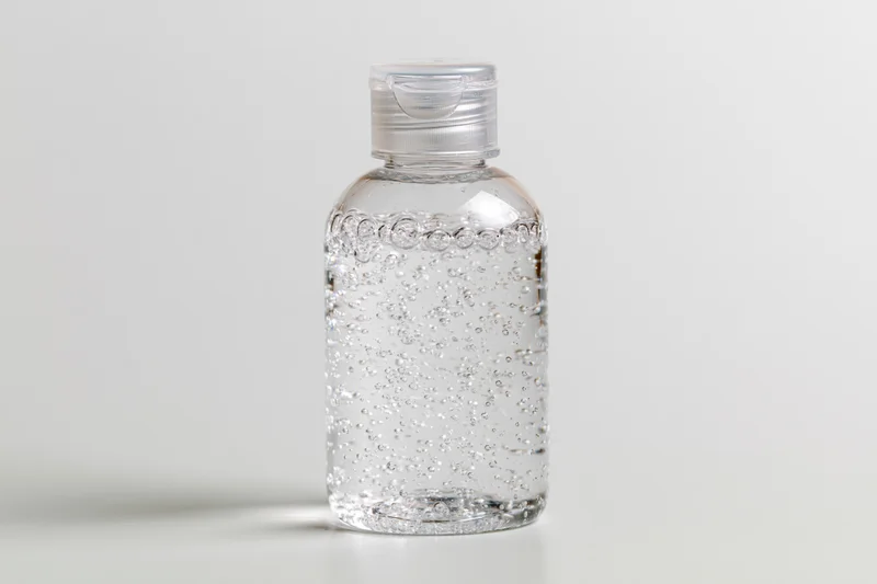Clear plastic bottle of hand sanitizer gel on white background