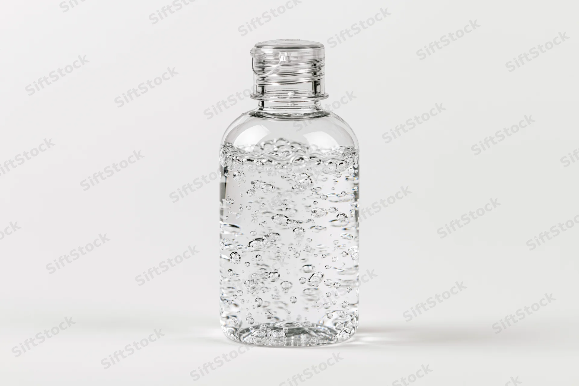 Clear plastic bottle filled with gel hand sanitizer on white background