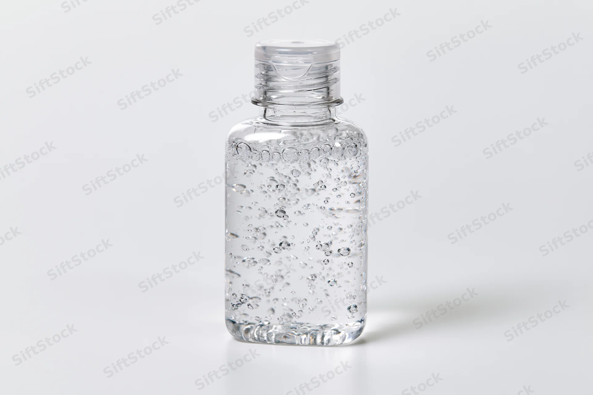 Clear plastic hand sanitizer bottle filled with gel on white background