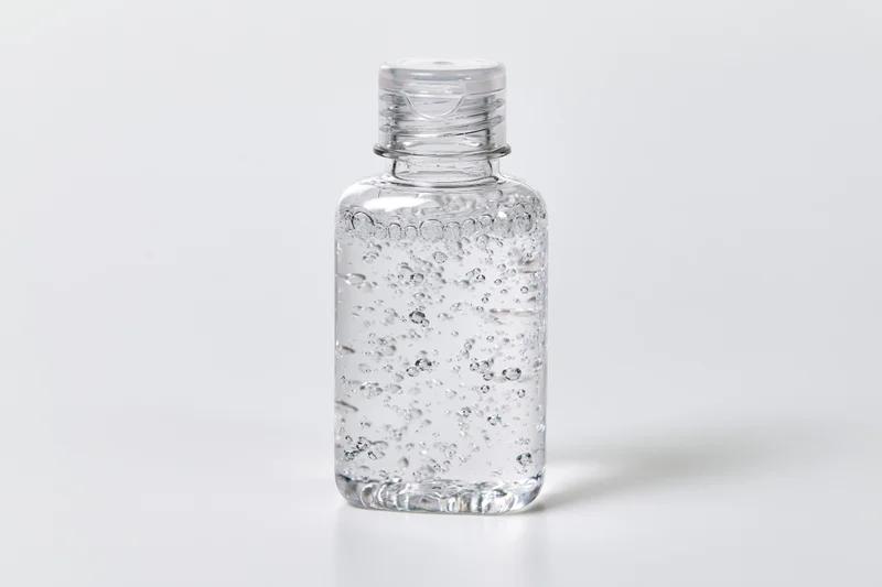 Clear plastic hand sanitizer bottle filled with gel on white background