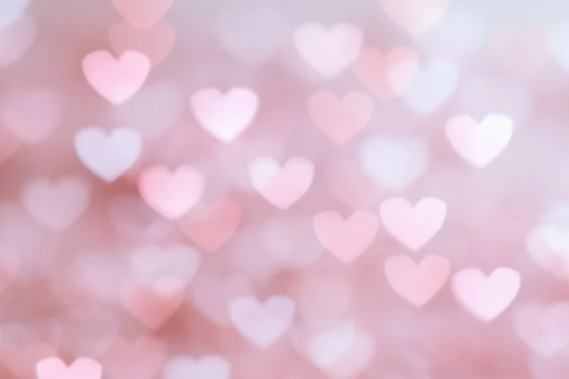 Soft bokeh background with out-of-focus heart shapes in pink and white