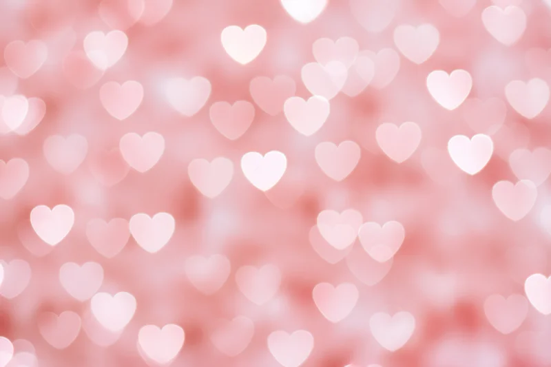 Soft pink bokeh background with out-of-focus heart shapes