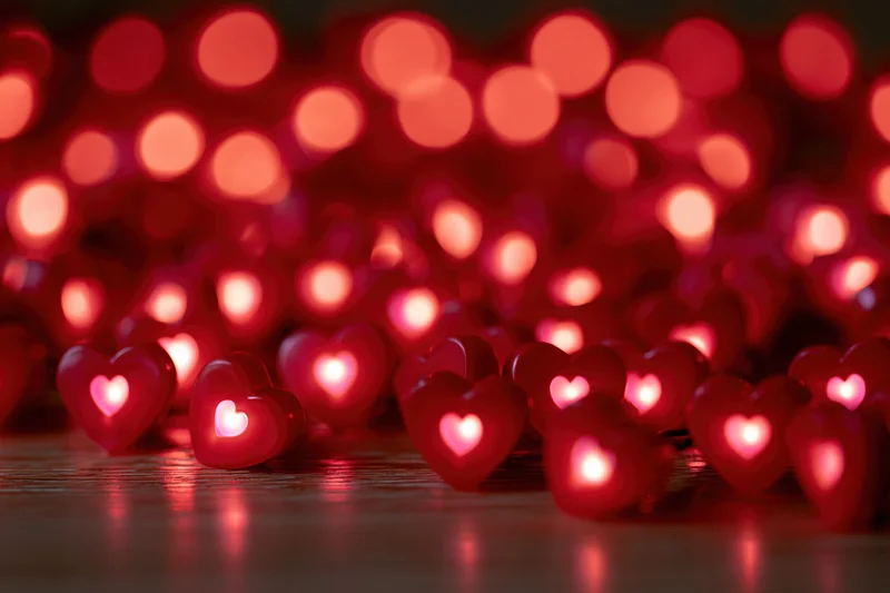 Heart-shaped lights glowing on a wooden surface with soft bokeh background