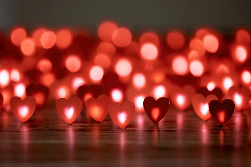 Heart-shaped lights glowing on a wooden surface with soft bokeh background
