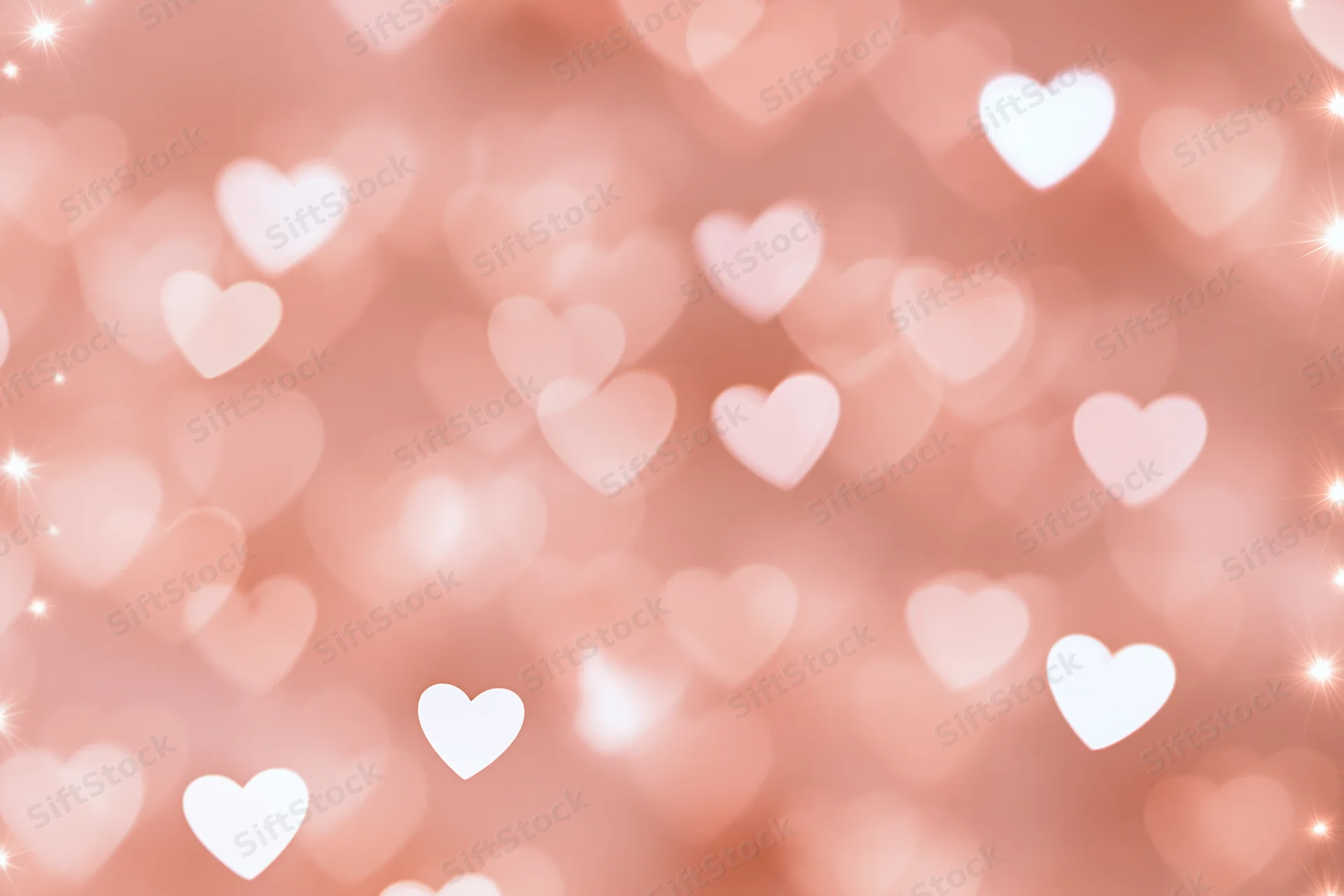 Soft pink bokeh background with scattered white heart shapes