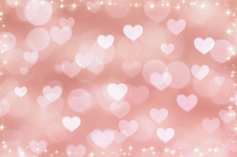 Soft pink bokeh background with scattered white heart shapes and sparkling lights