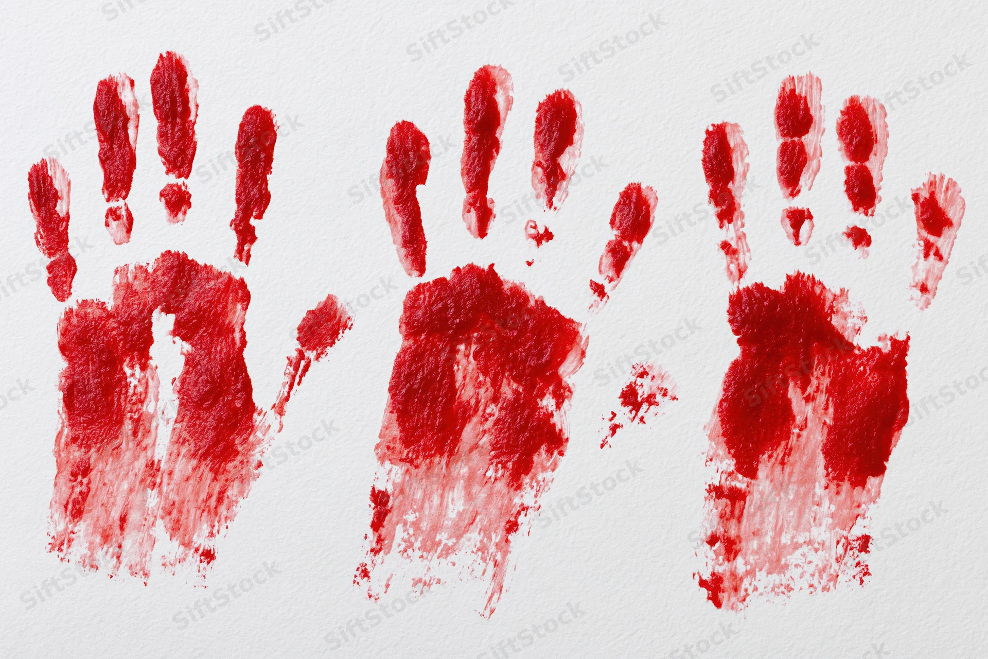 Three red handprints pressed and dragged downward on white paper