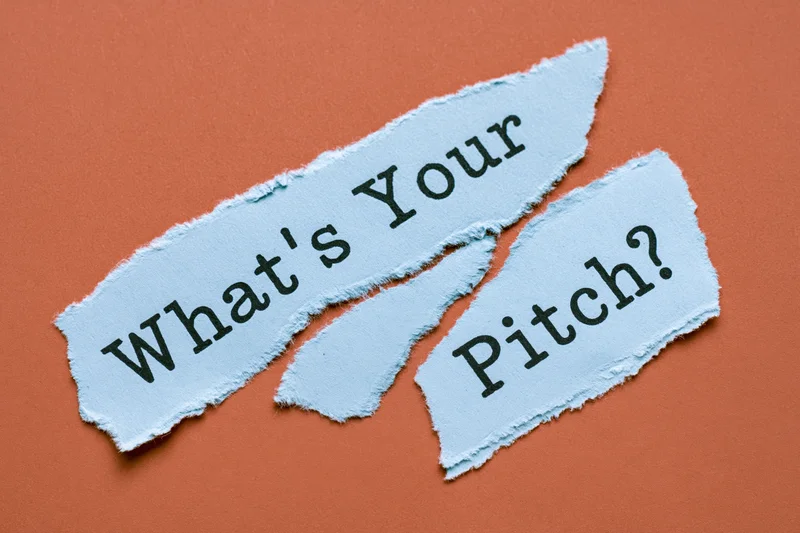 Torn blue paper strips with text reading what's your pitch on orange background
