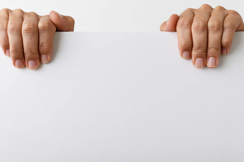 Hands gripping the top edge of a white blank sign