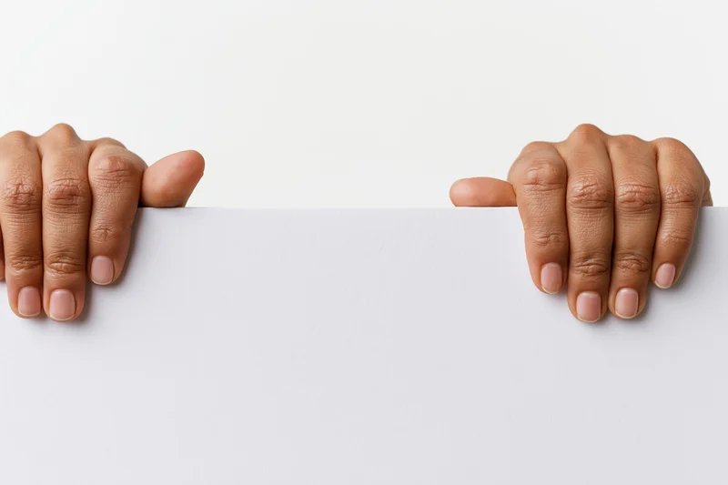Two hands gripping the top edge of a white blank sign