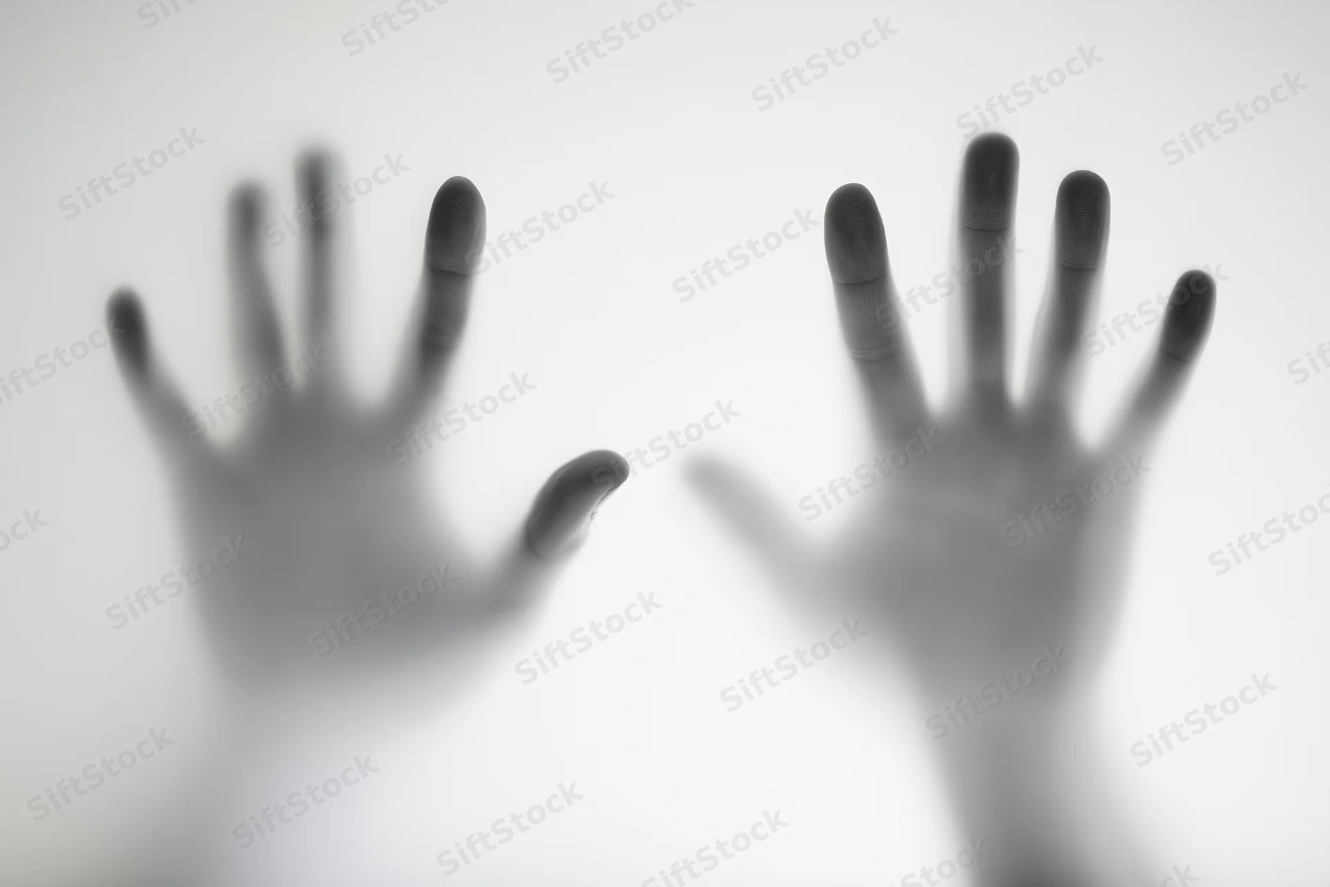 Two hands pressing against a translucent white surface