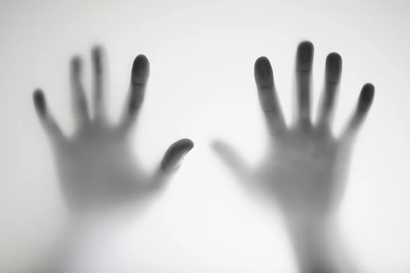 Two hands pressing against a translucent white surface
