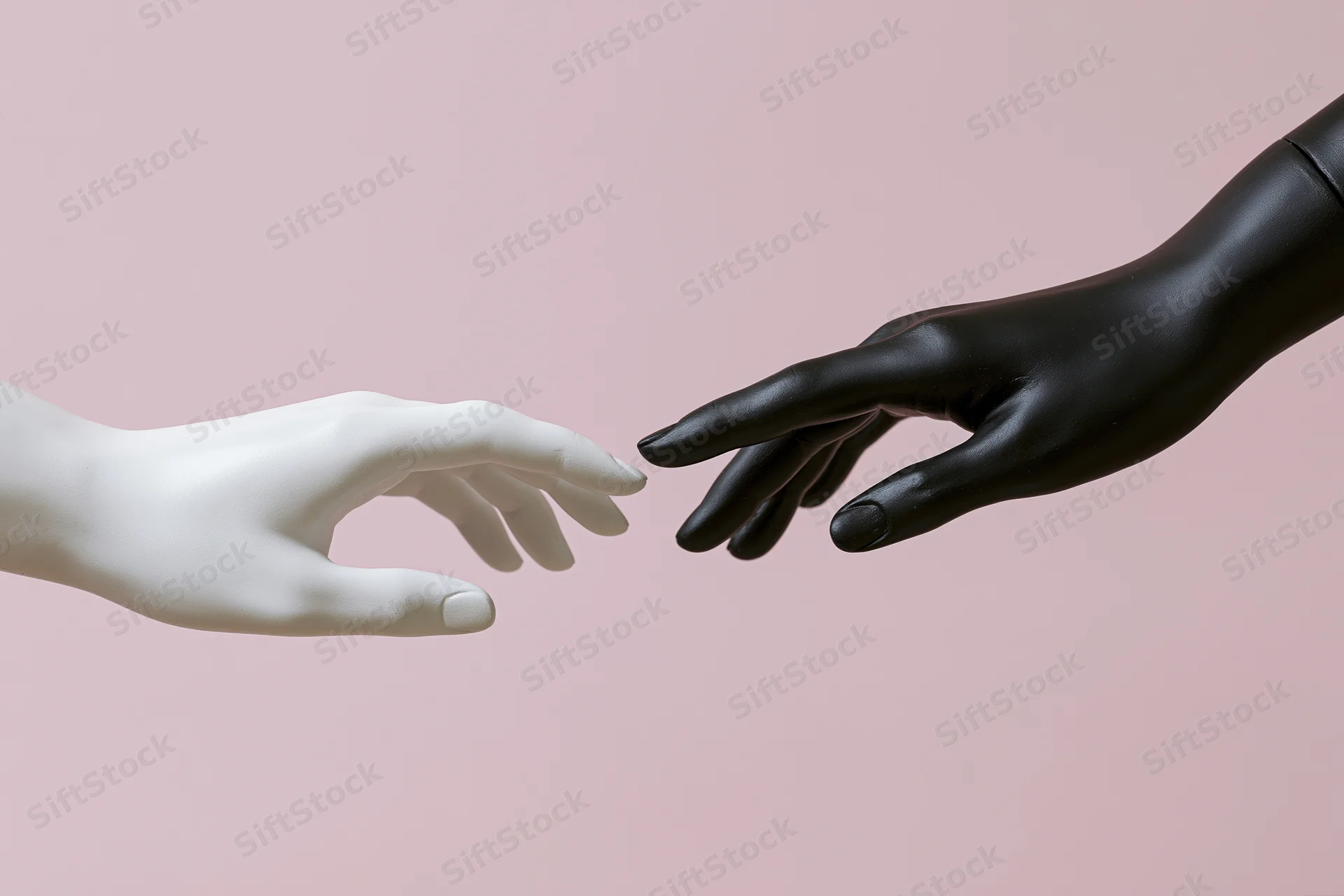 Two mannequin hands reaching toward each other almost touching against a pink background