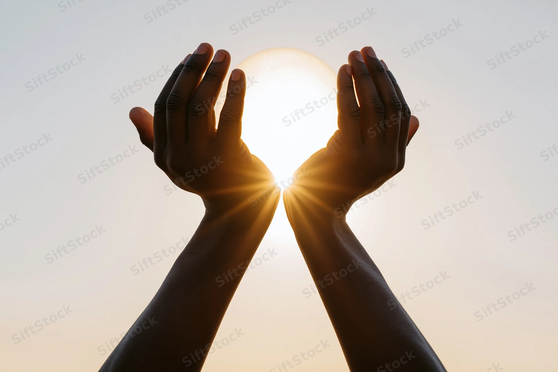 Hands cupping the sun against a glowing sky at sunrise
