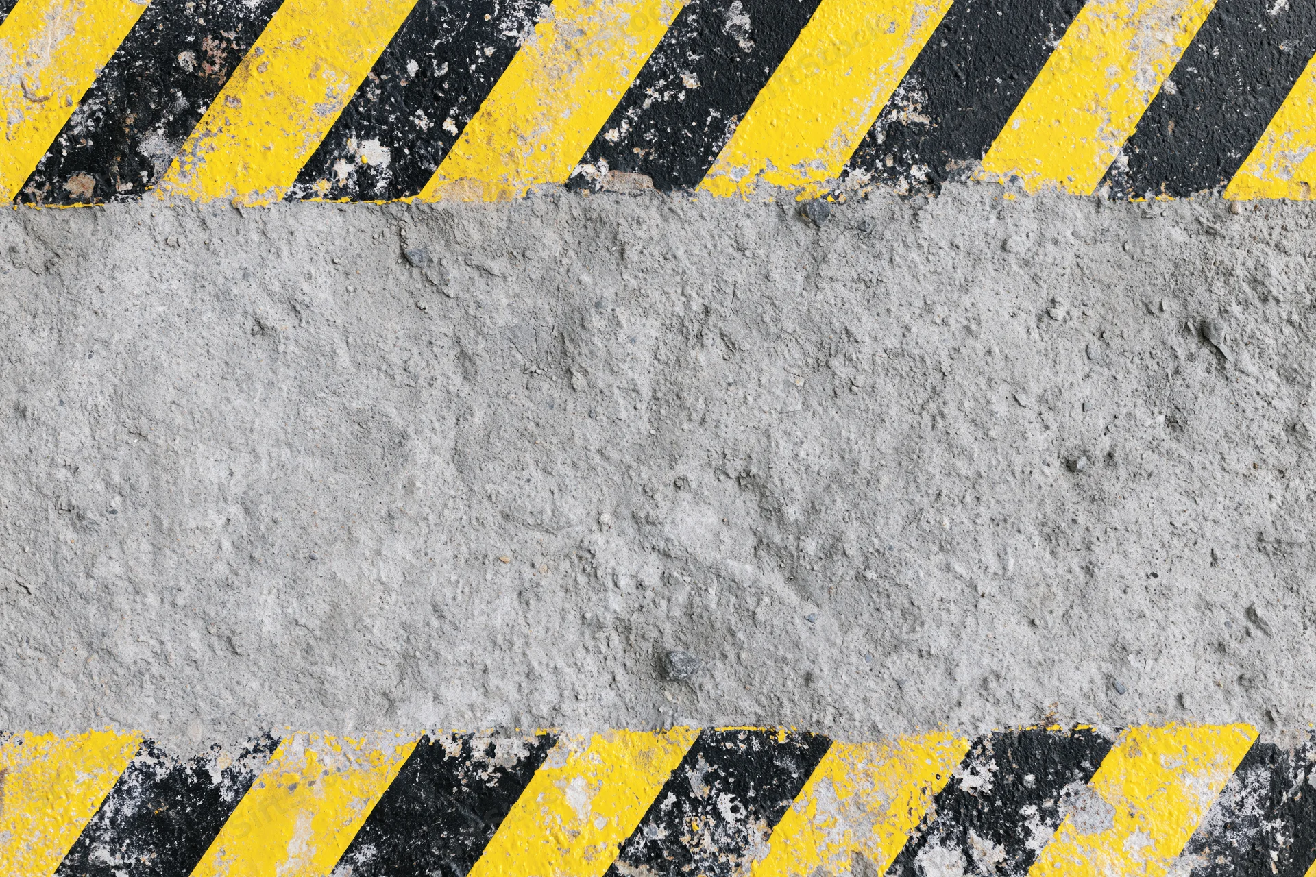 Weathered concrete surface with diagonal yellow and black hazard stripes