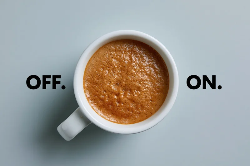 Overhead view of a white ceramic mug filled with espresso crema on a light gray surface with text labels off and on on either side
