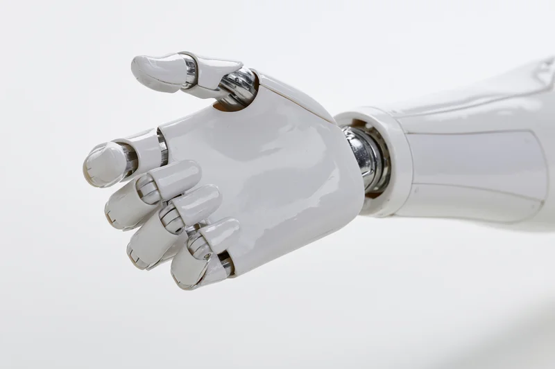 White robotic hand with slightly curled fingers extending from forearm against plain background