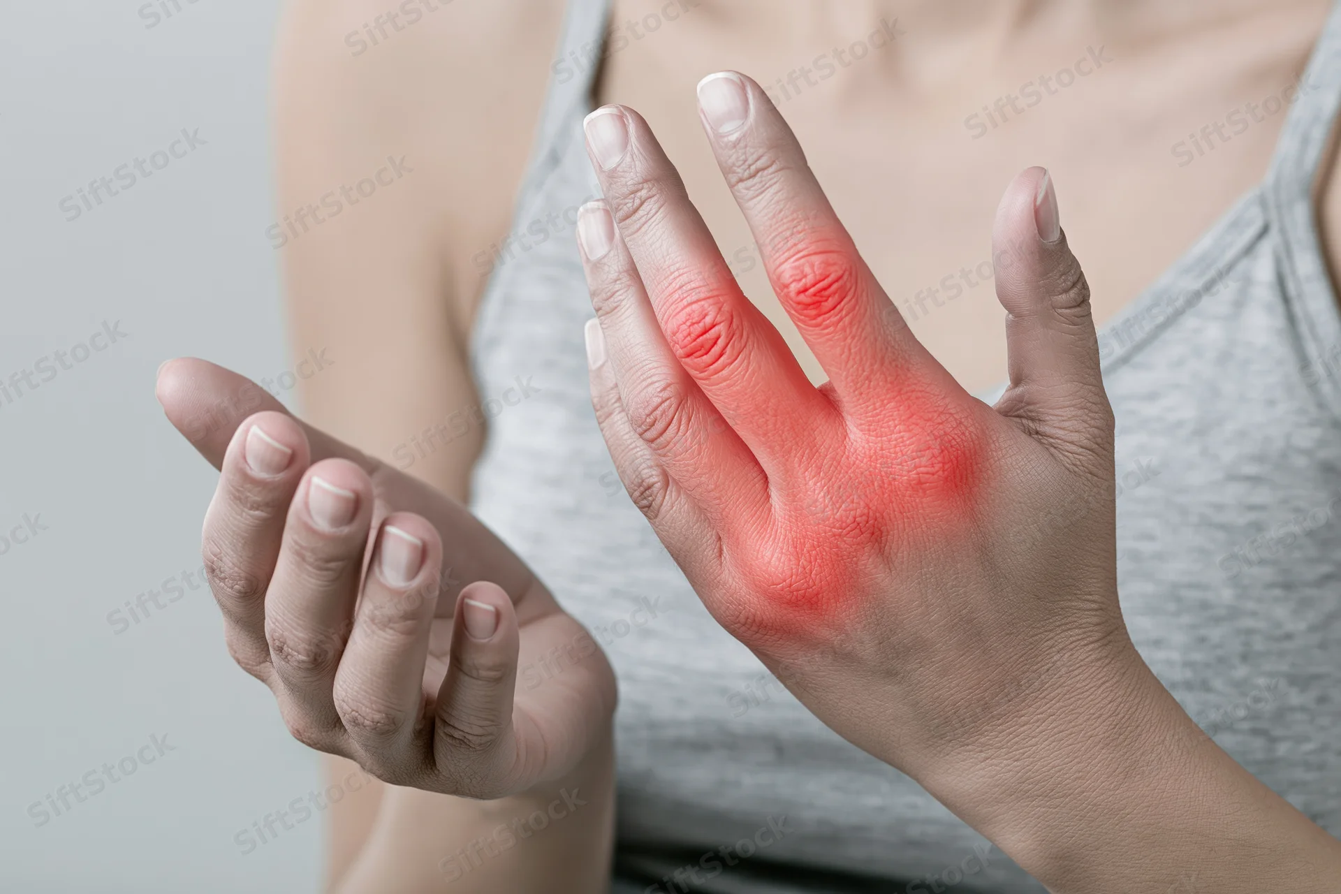 Woman holding her hand with red highlighted areas on fingers and knuckles indicating pain