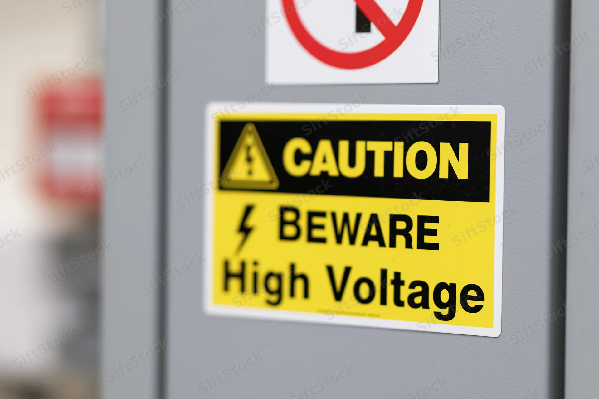 Caution beware high voltage warning label on gray electrical panel