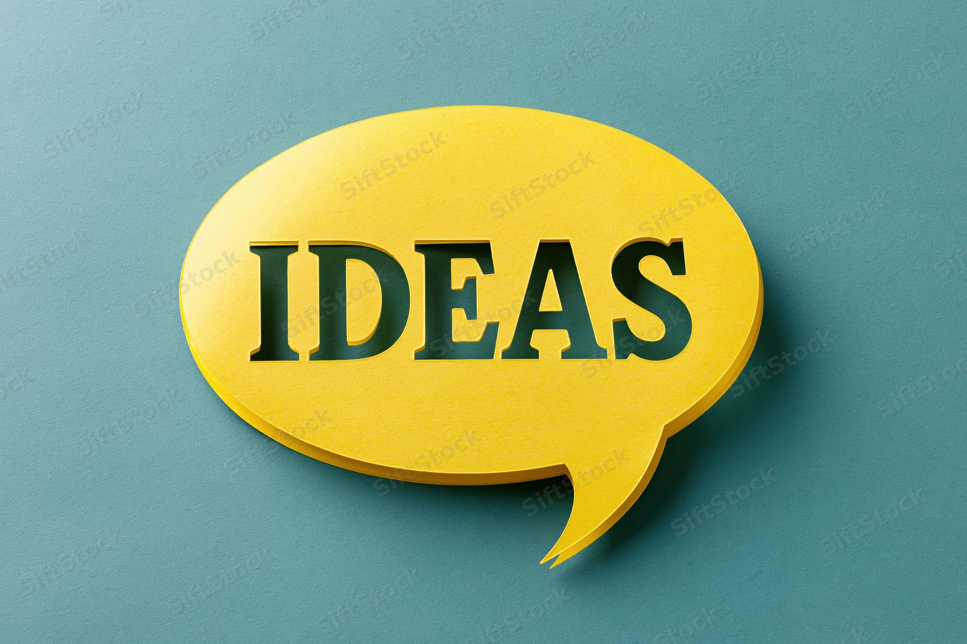 Yellow paper speech bubble with cutout word ideas on blue background