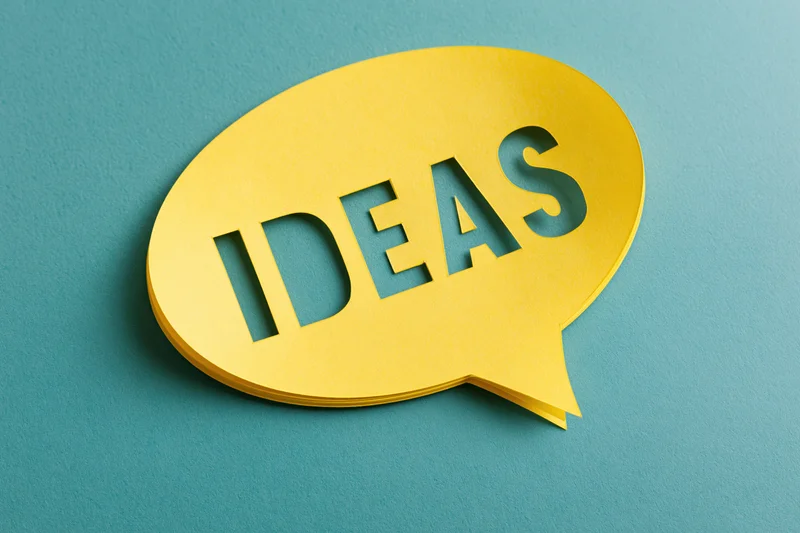 Yellow paper speech bubble with cutout text ideas on blue background