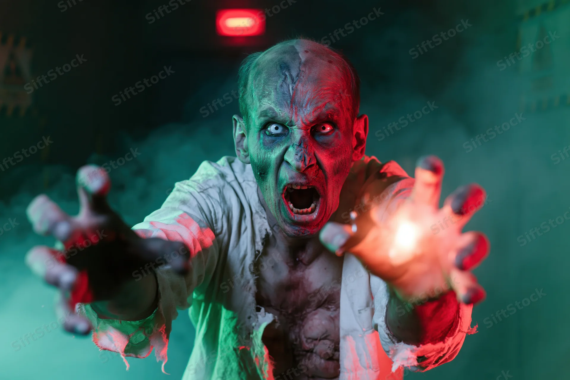 Zombie with decayed green skin screaming and clawing forward in smoky dark setting