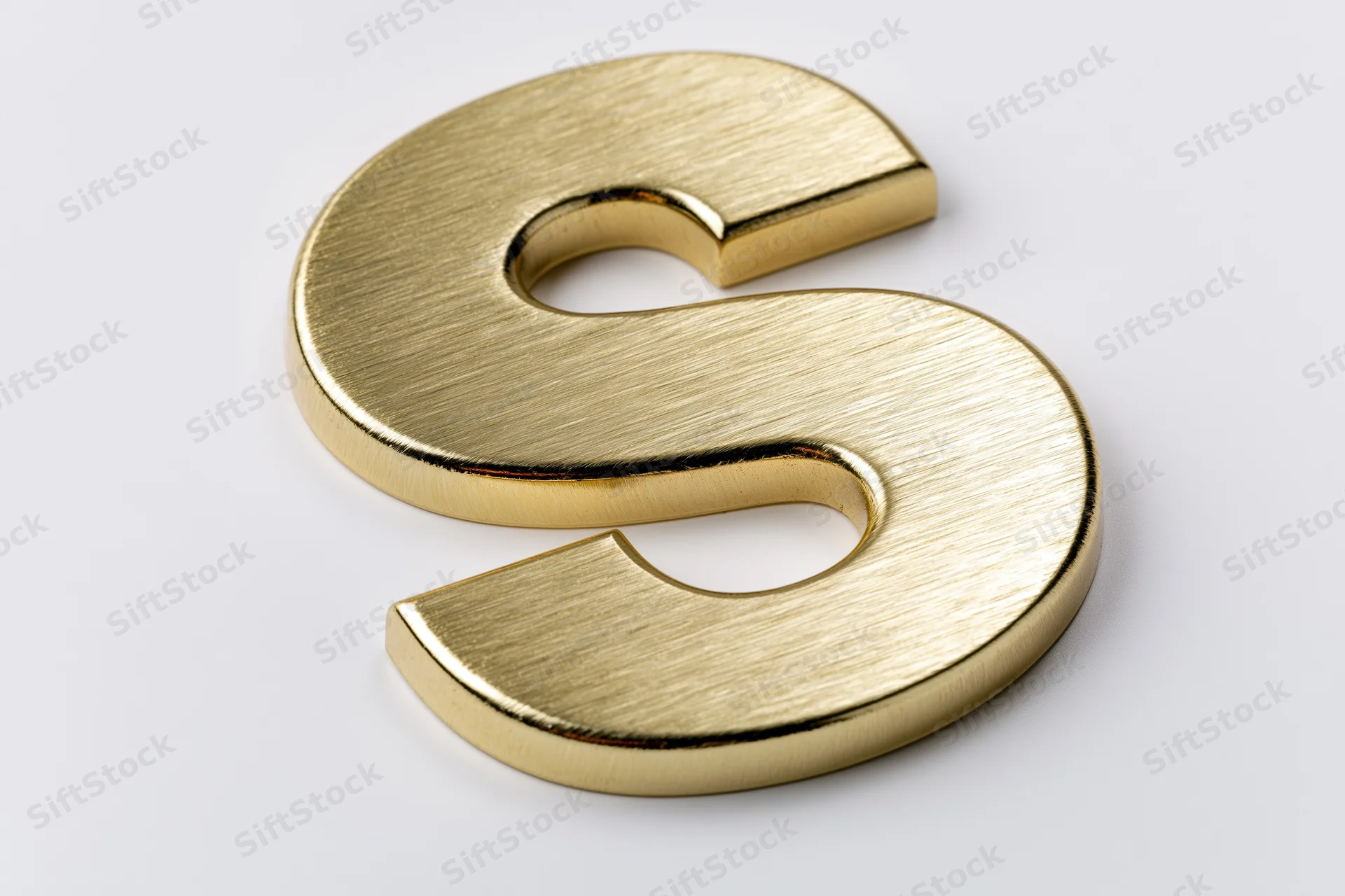 Golden three-dimensional letter s on a white surface