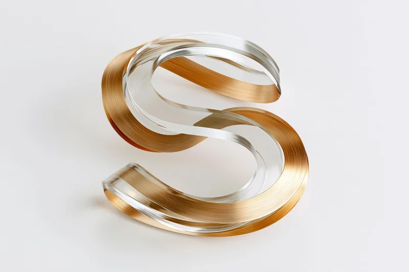 Metallic 3d letter s sculpture with layered gold and silver surfaces on white background