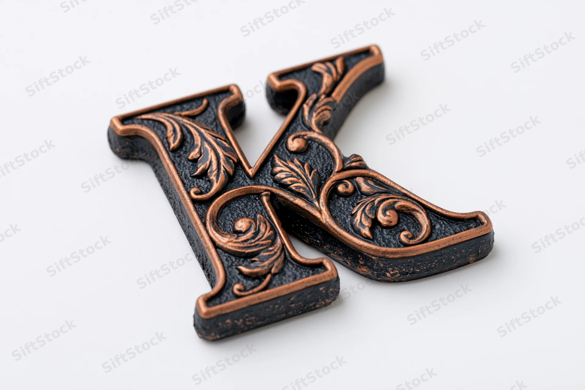 Ornate three-dimensional letter k with floral scrollwork on white background