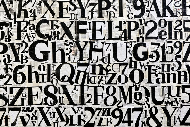 Dense collage of cut-out letters and numbers arranged on paper background