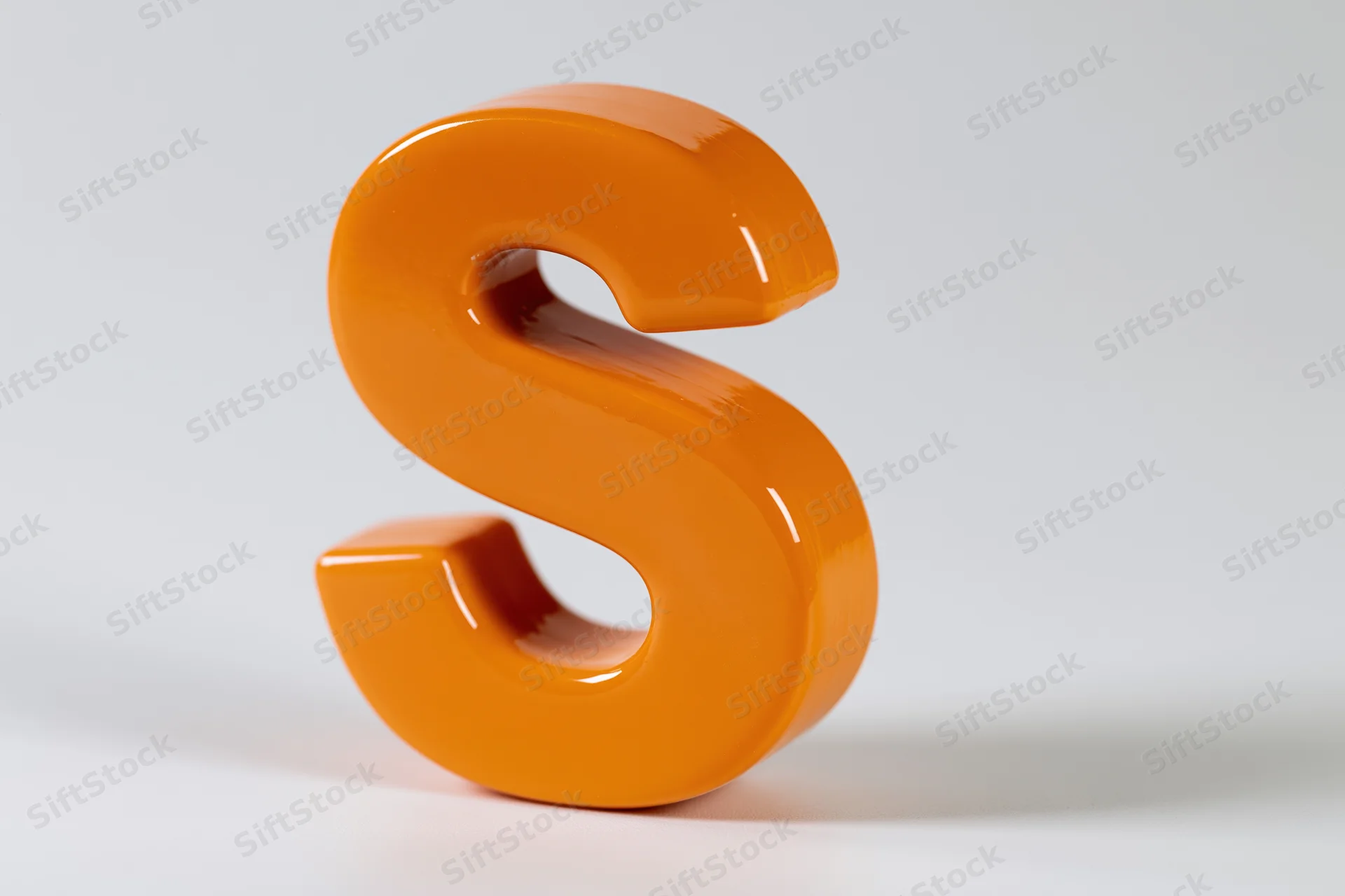Glossy orange three-dimensional letter s standing upright on white background