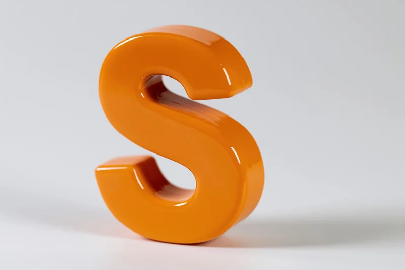 Glossy orange three-dimensional letter s standing upright on white background
