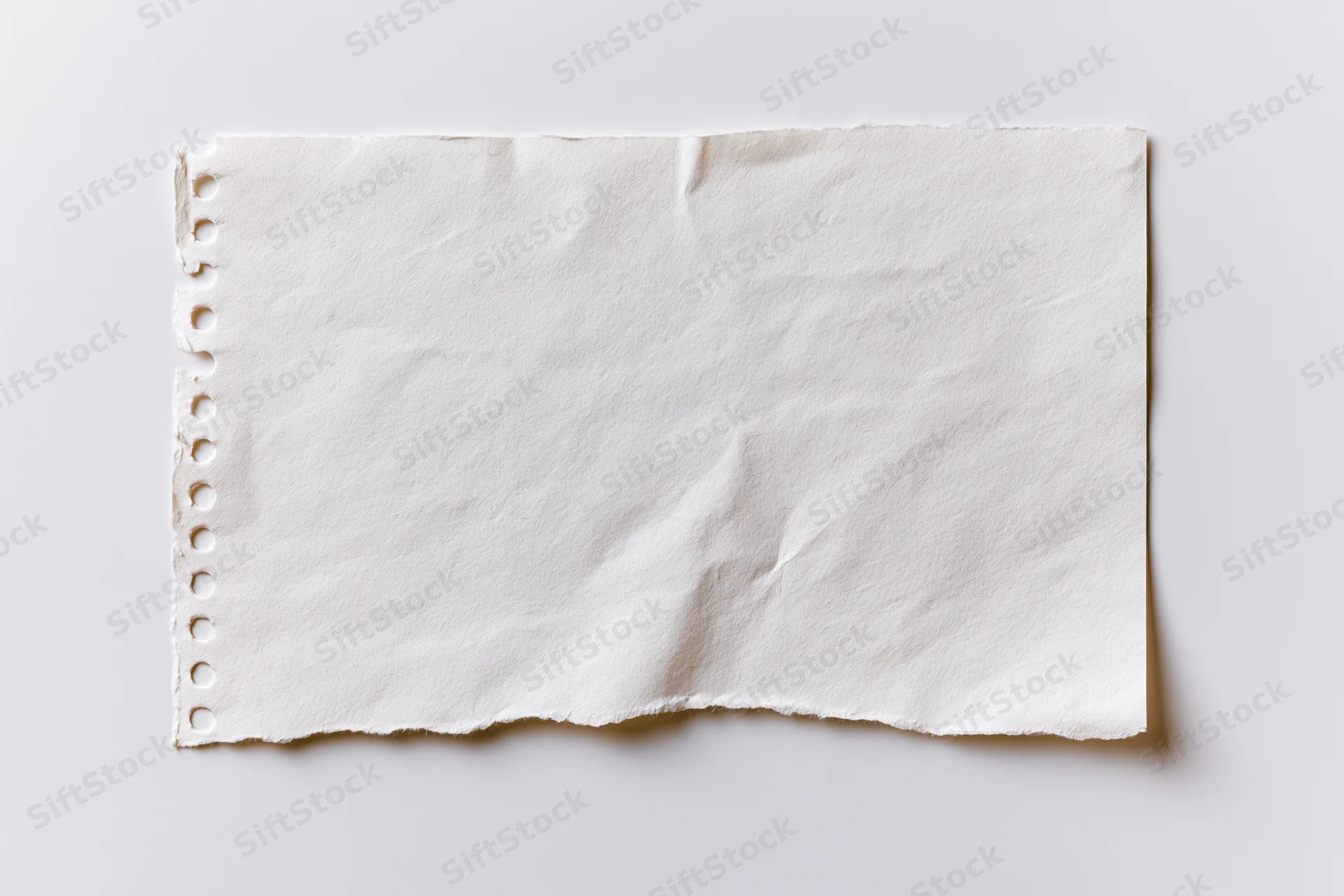 Torn blank notebook page with spiral binding lying flat on white surface