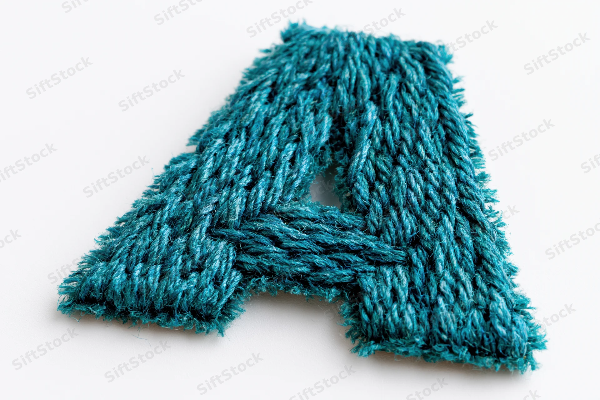 Knitted letter a in teal yarn isolated on white background