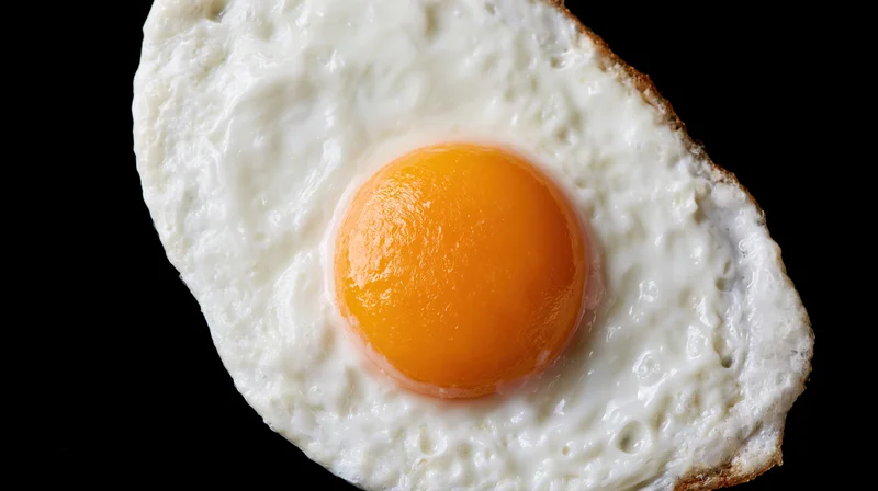 Fried egg sunny-side-up on black background