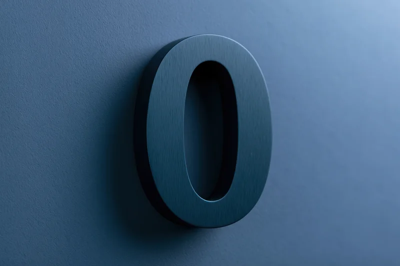 Three-dimensional matte dark teal zero mounted on a textured blue wall
