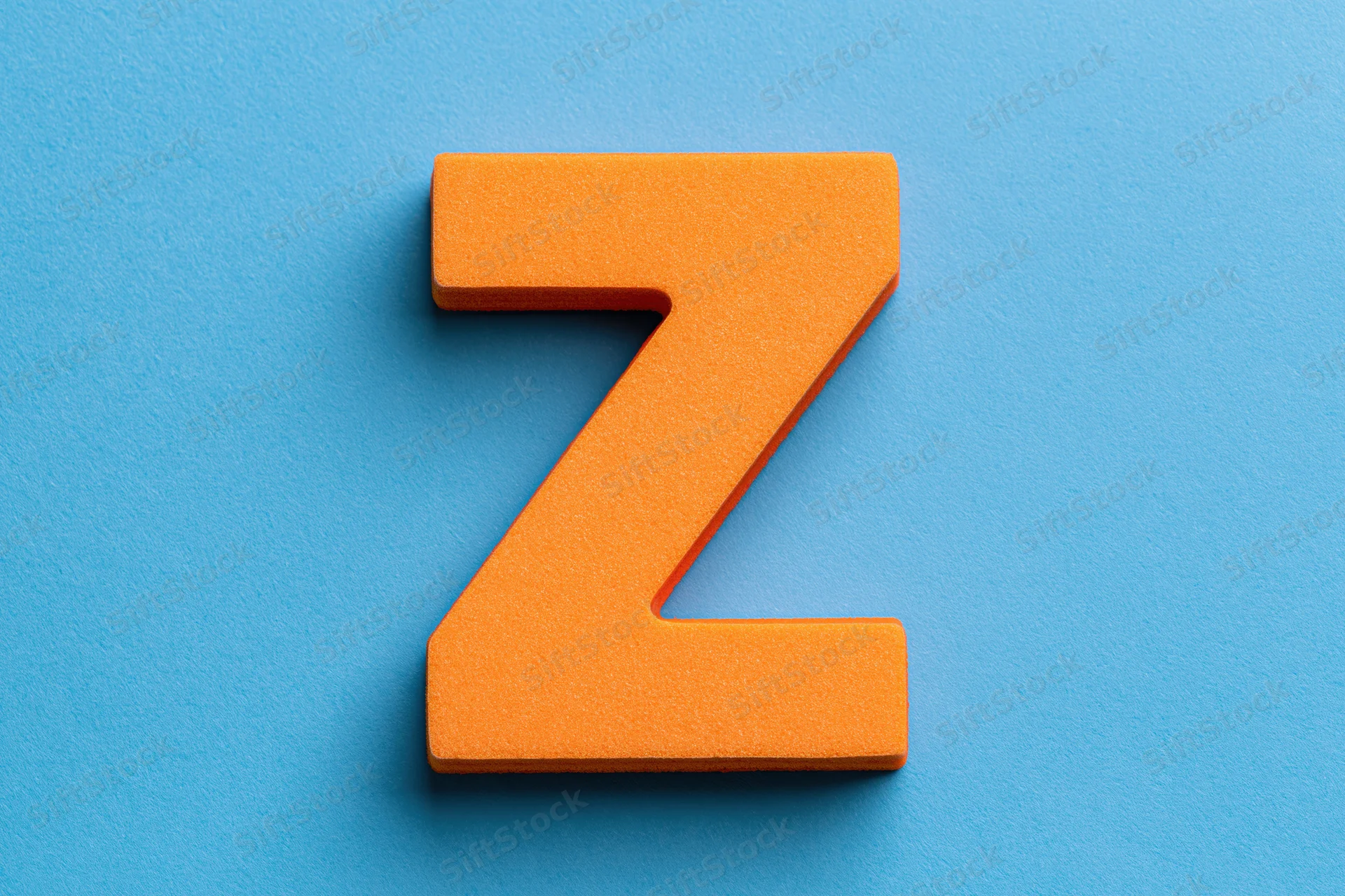 Orange foam letter z centered on bright blue background