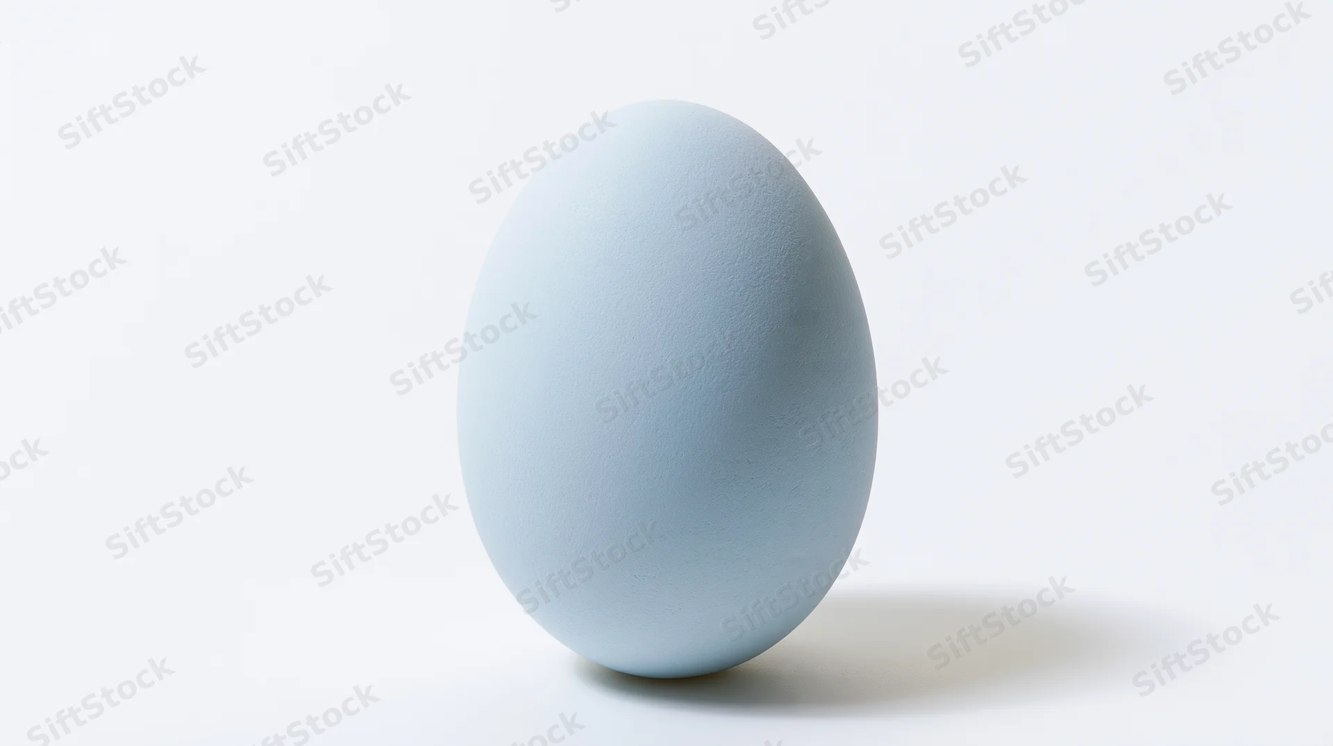 Pale blue egg standing upright on white background