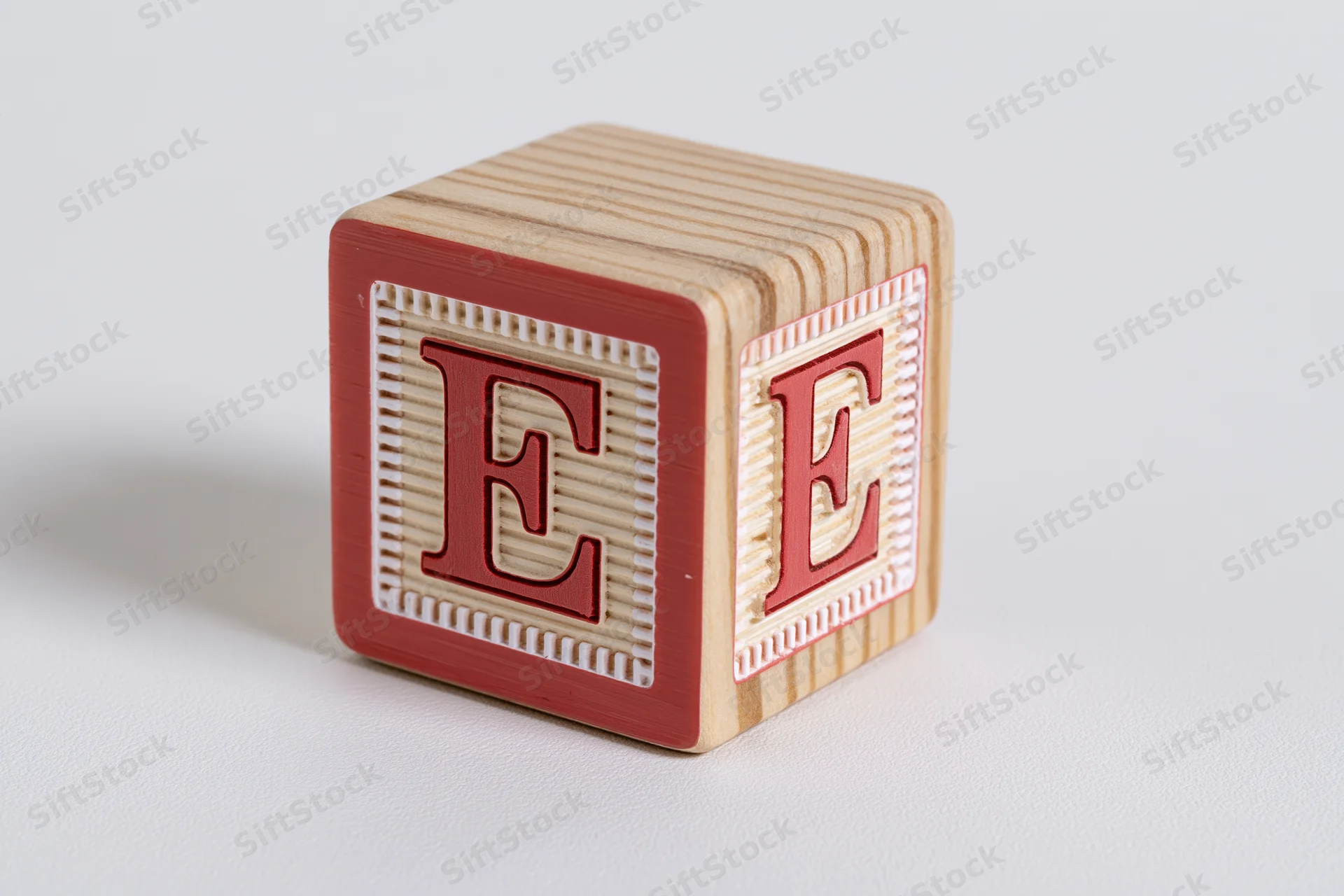 Wooden alphabet block with letter e on white background
