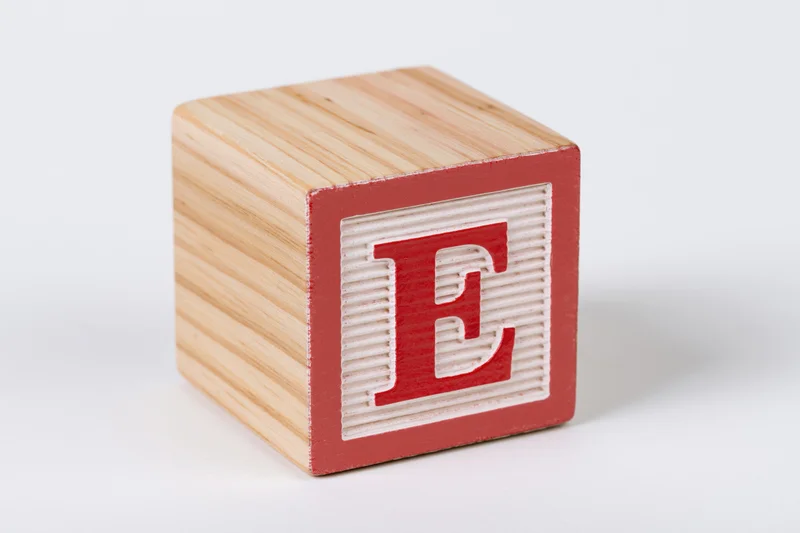 Wooden alphabet block with letter e on white background