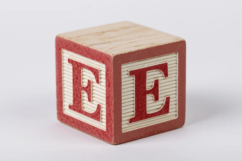 Wooden alphabet block with letter e on white background